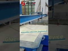 How does the glue spraying device operate on the spray bonded wadding production line?